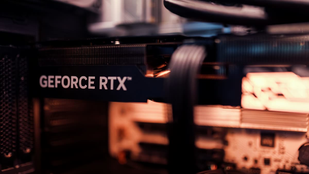 A GeForce RTX graphics card installed in a PC, lit warm